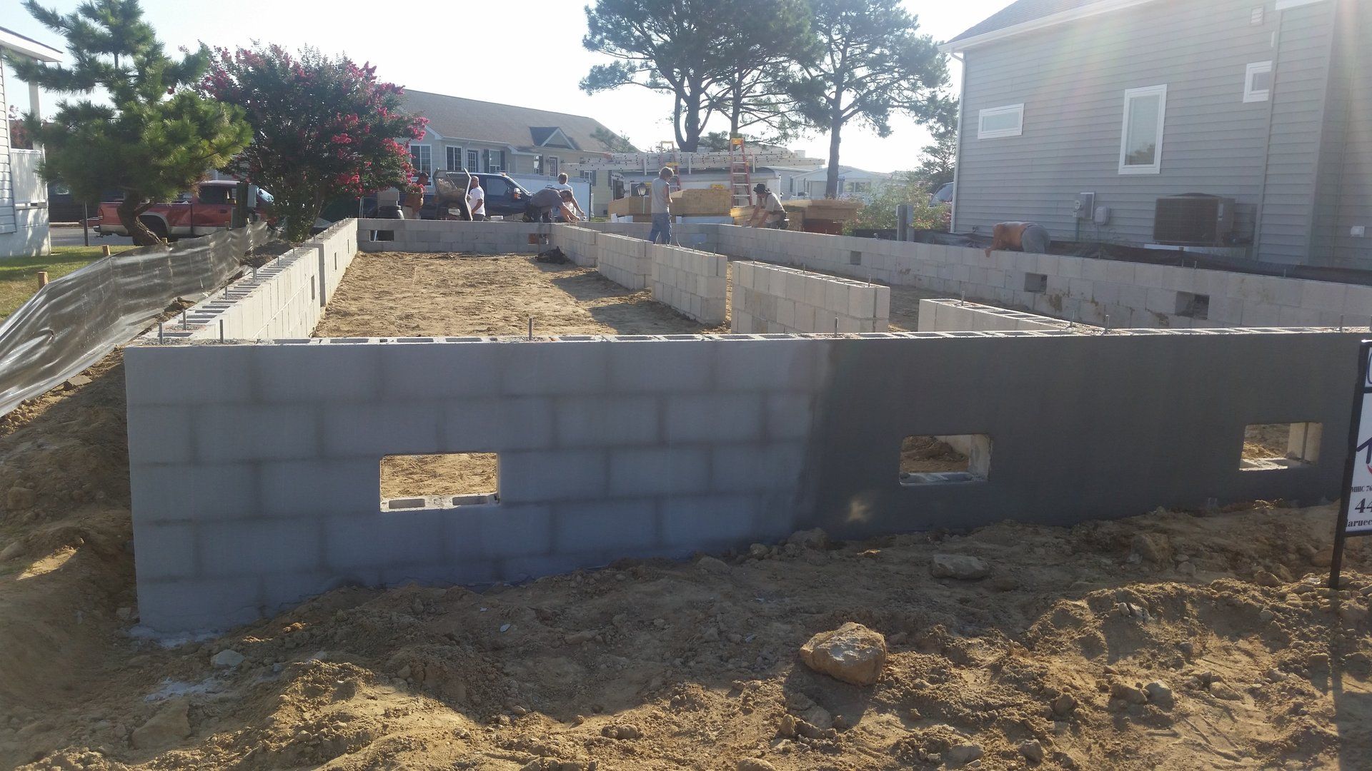 A brick wall is being built in front of a house