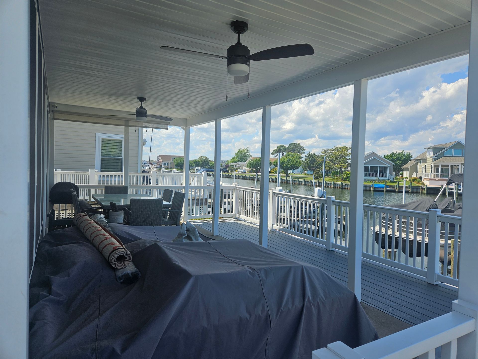There is a ceiling fan on the porch of a house