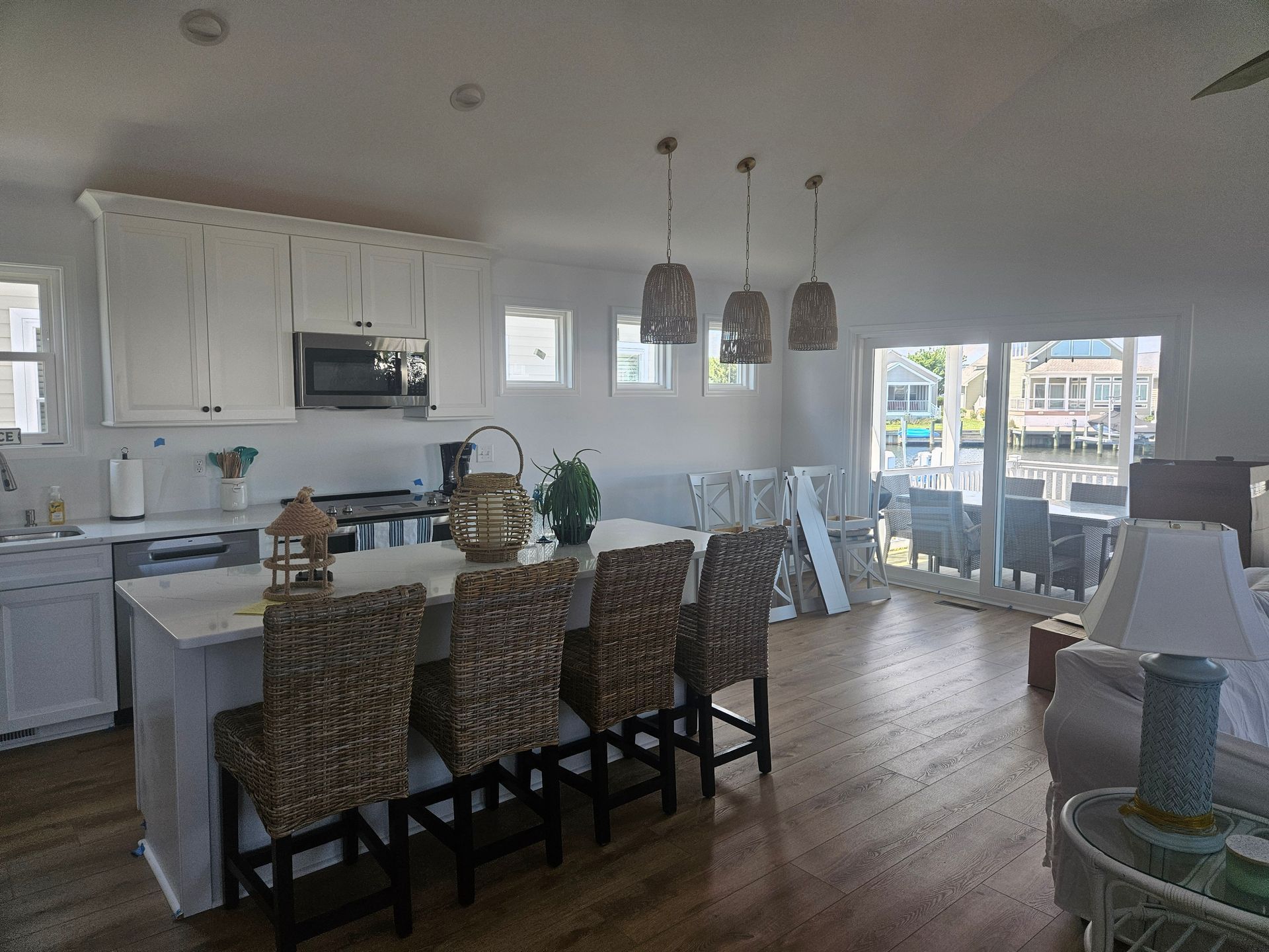 A kitchen with white cabinets and wicker chairs