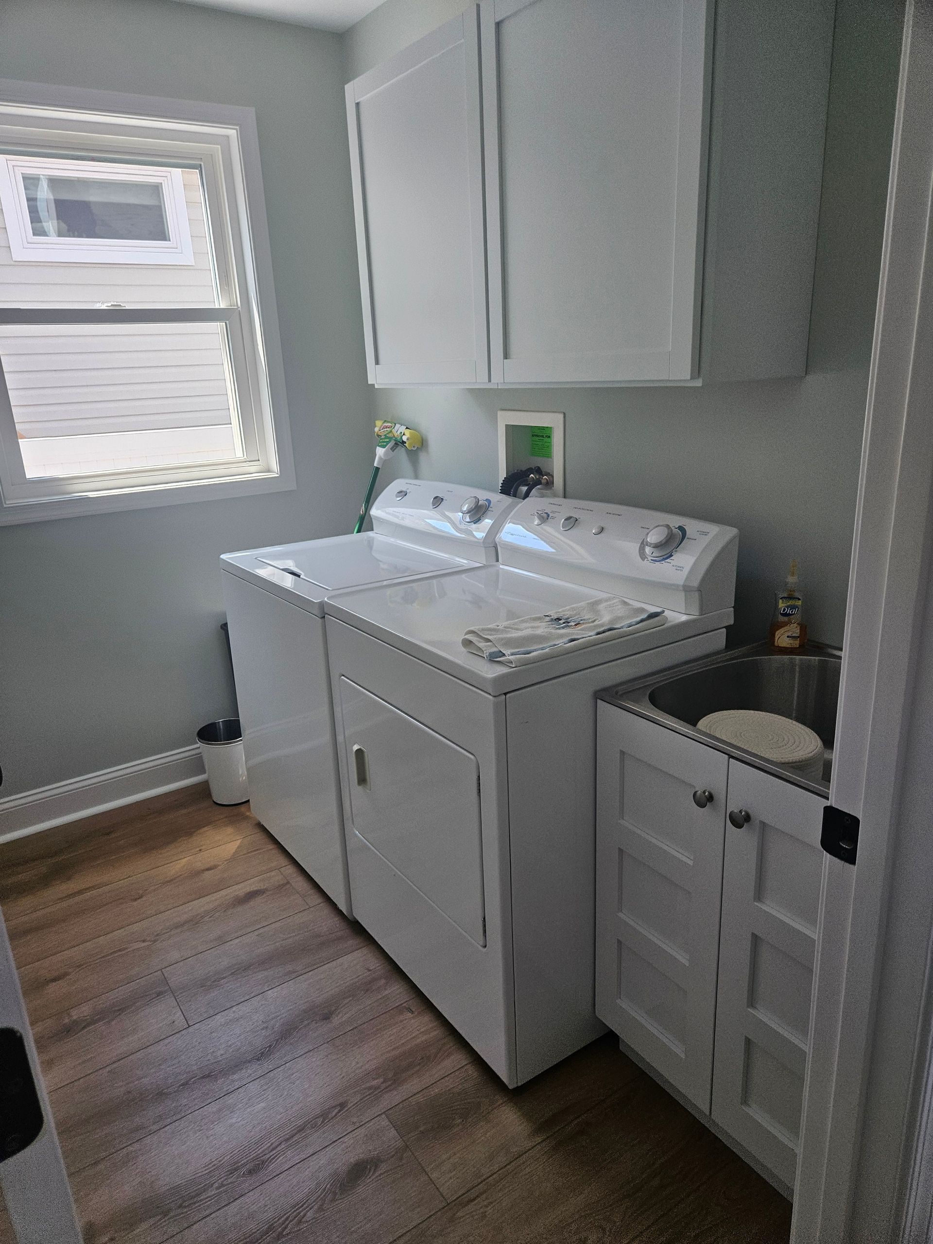 A laundry room with a washer and dryer and a sink