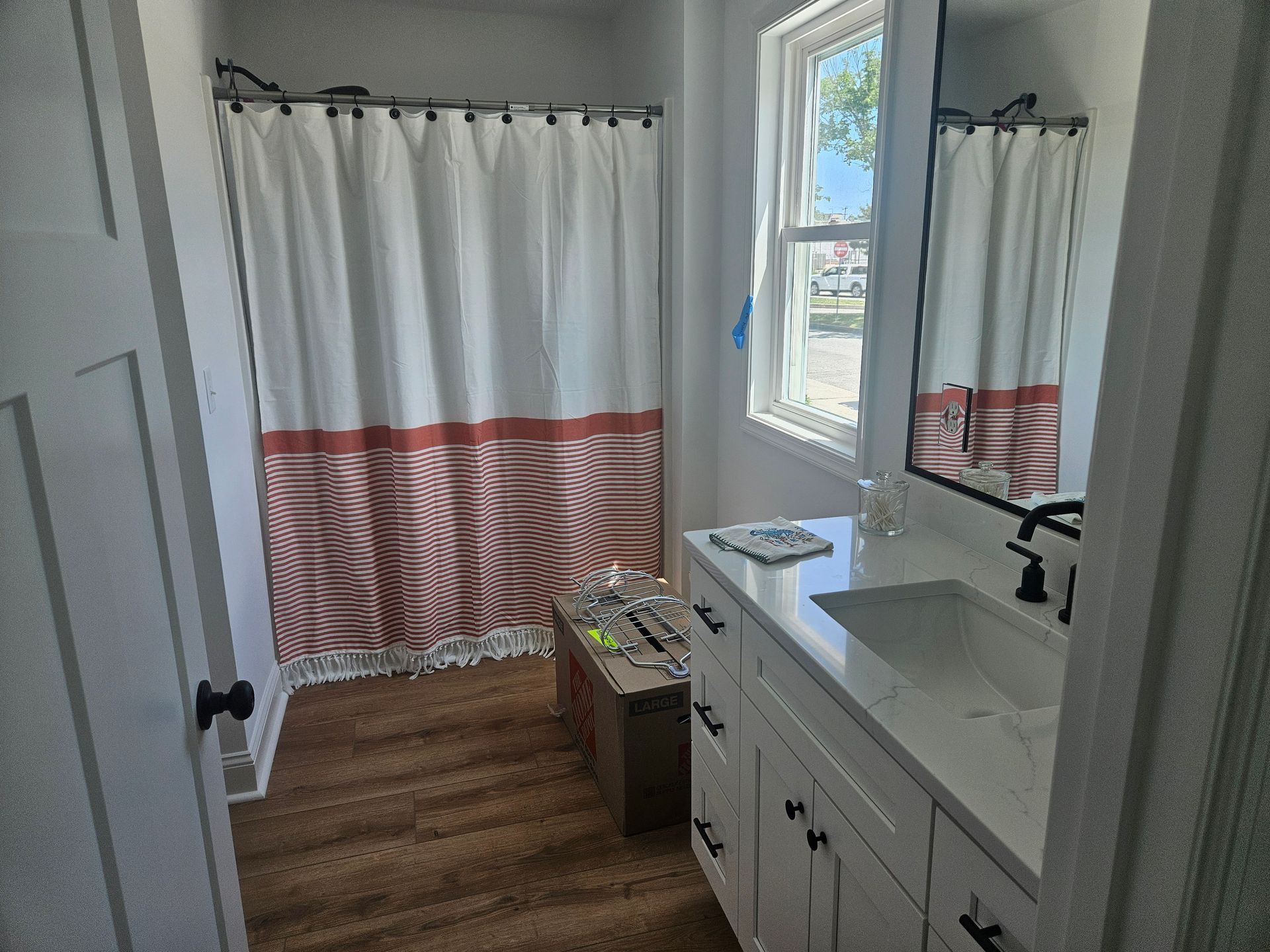 A bathroom with a sink, mirror and shower curtain