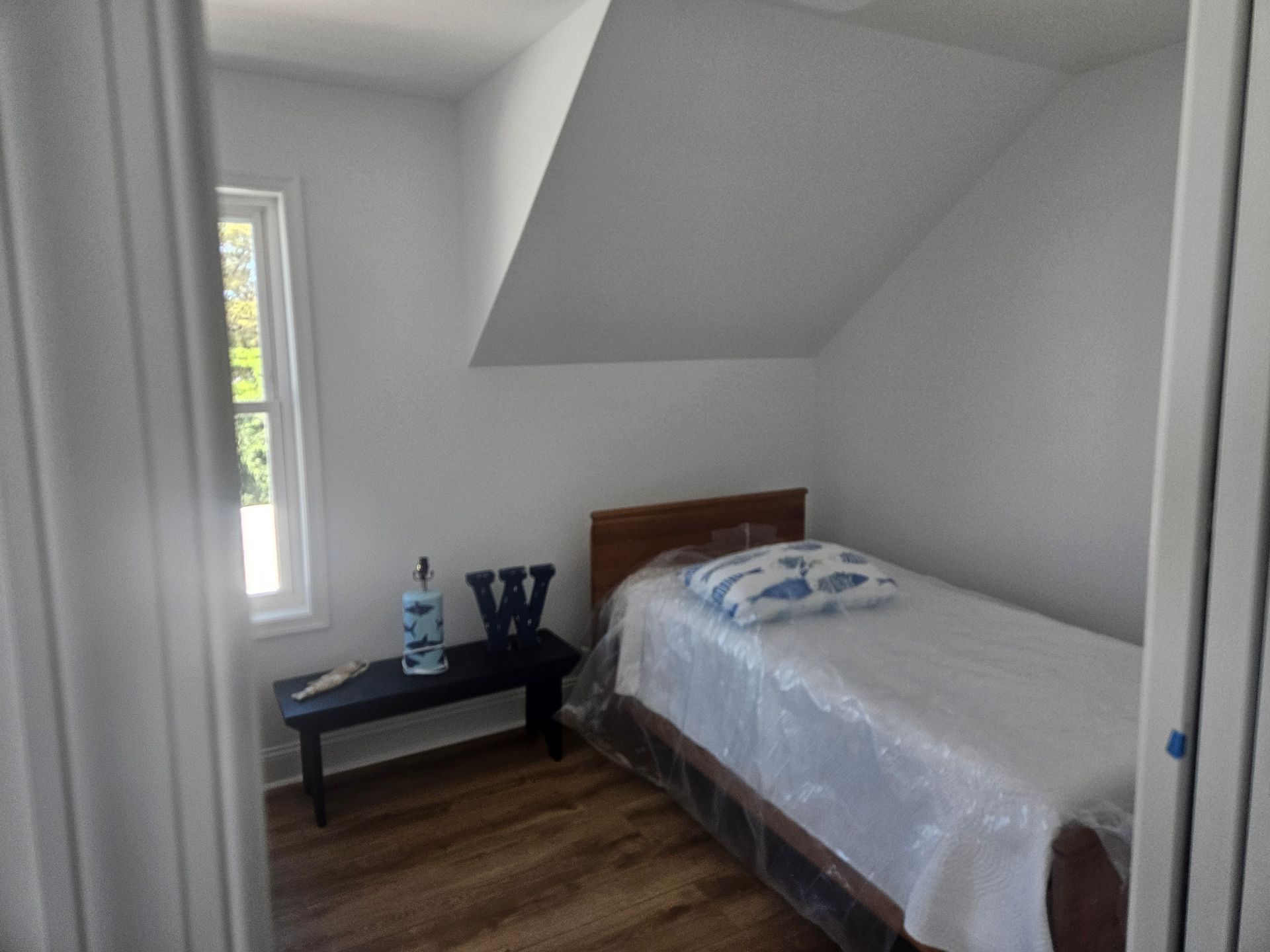 A bedroom with a single bed and a window