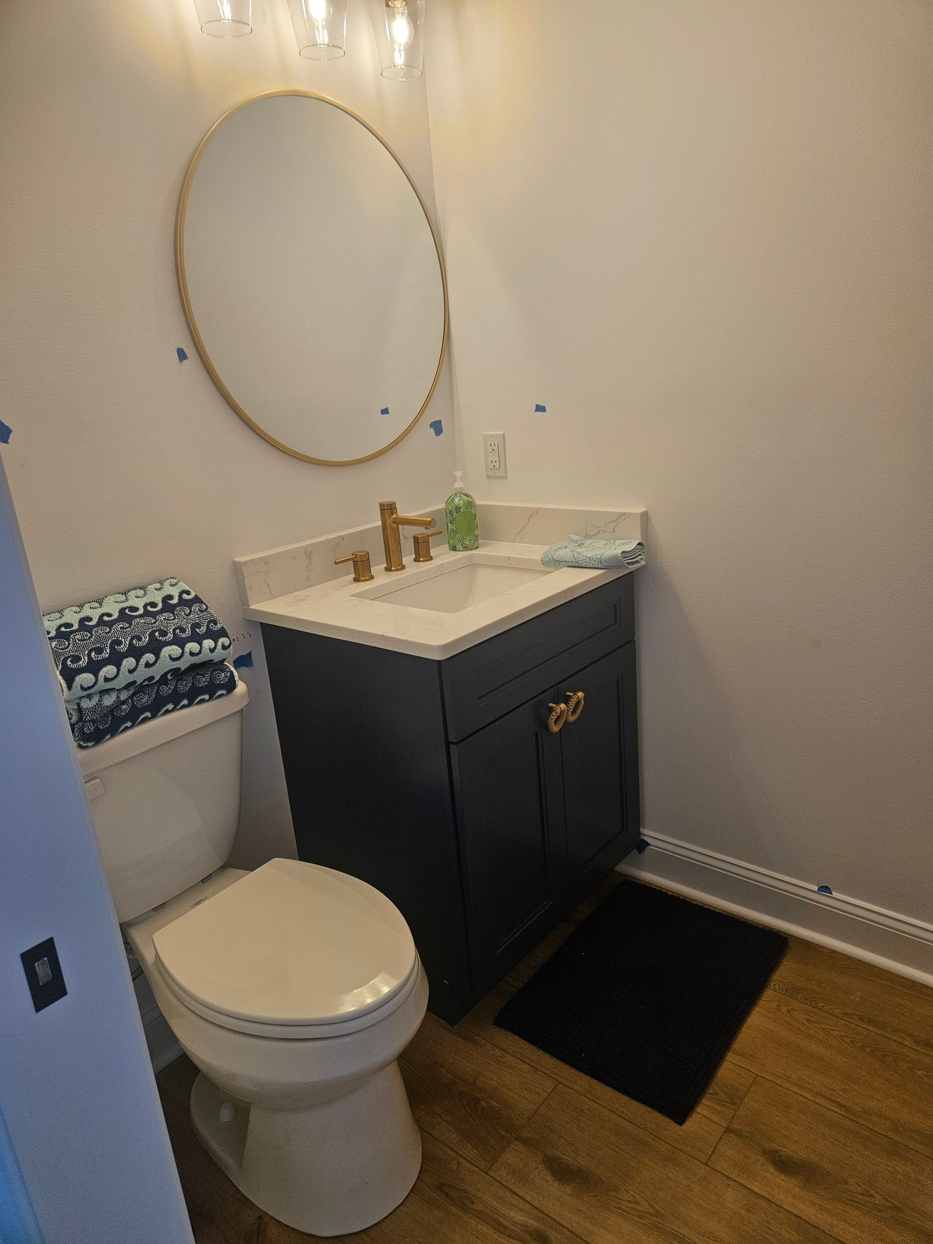 A bathroom with a toilet , sink and mirror