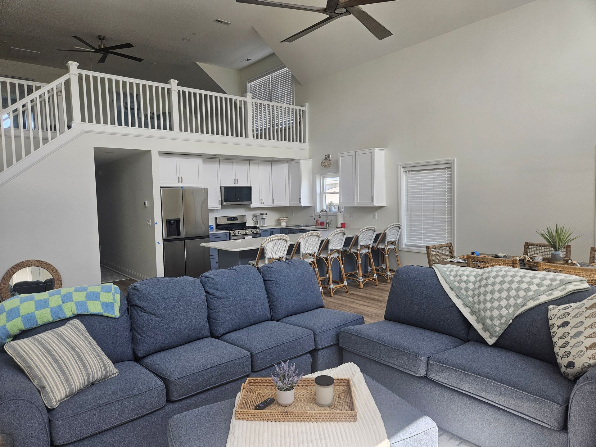 A living room with blue couches and a ceiling fan