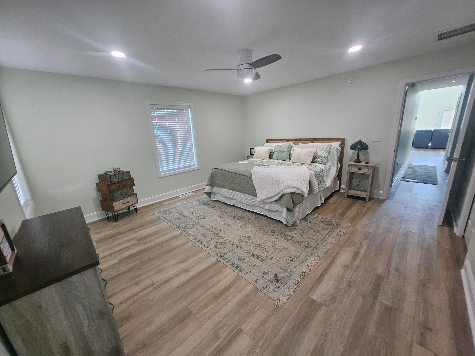 A bedroom with a king size bed and a ceiling fan
