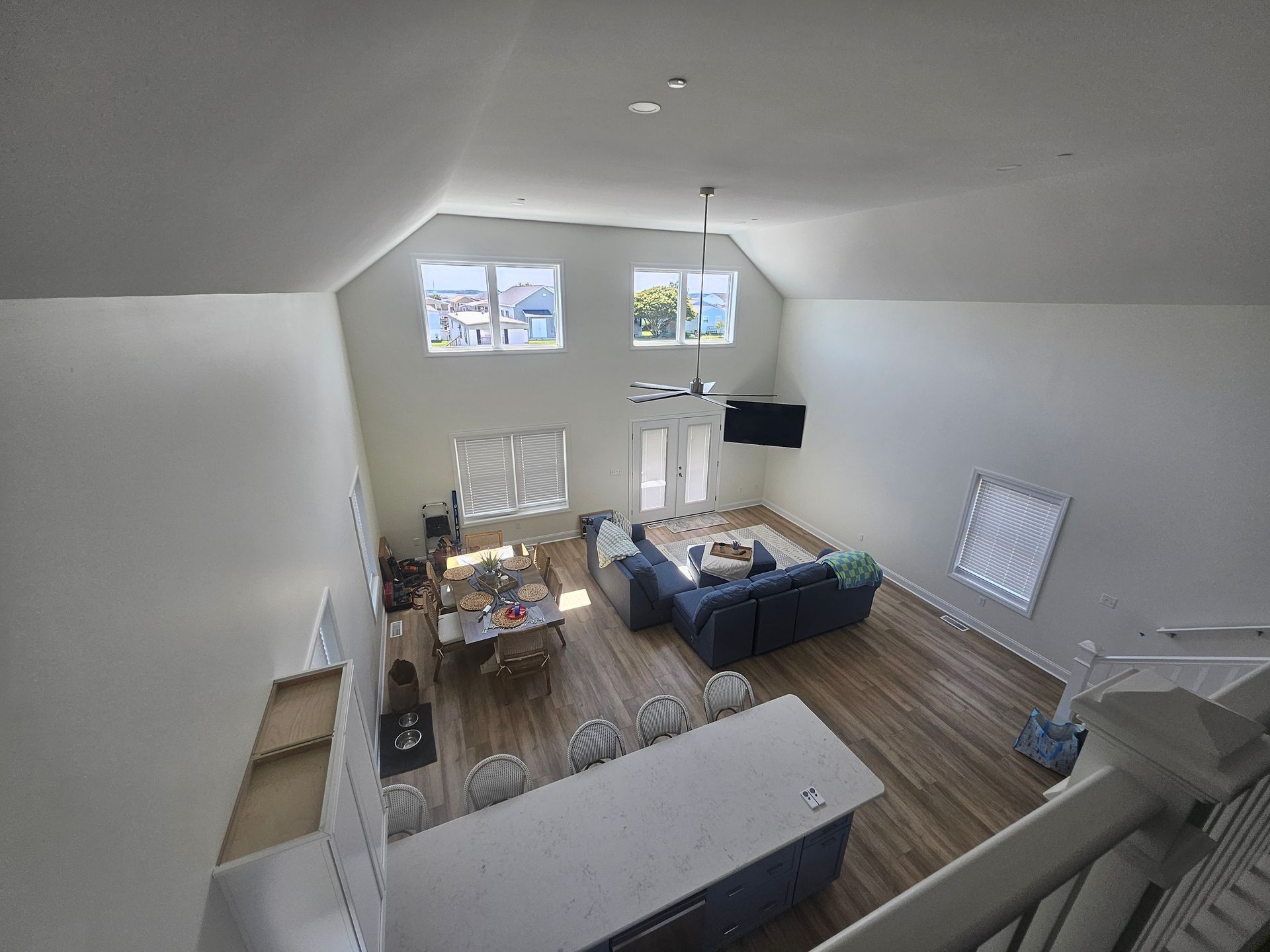An aerial view of a living room and kitchen from the second floor
