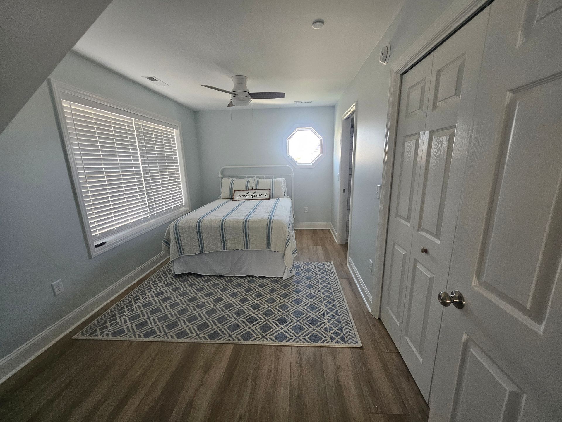 A bedroom with a bed and a ceiling fan