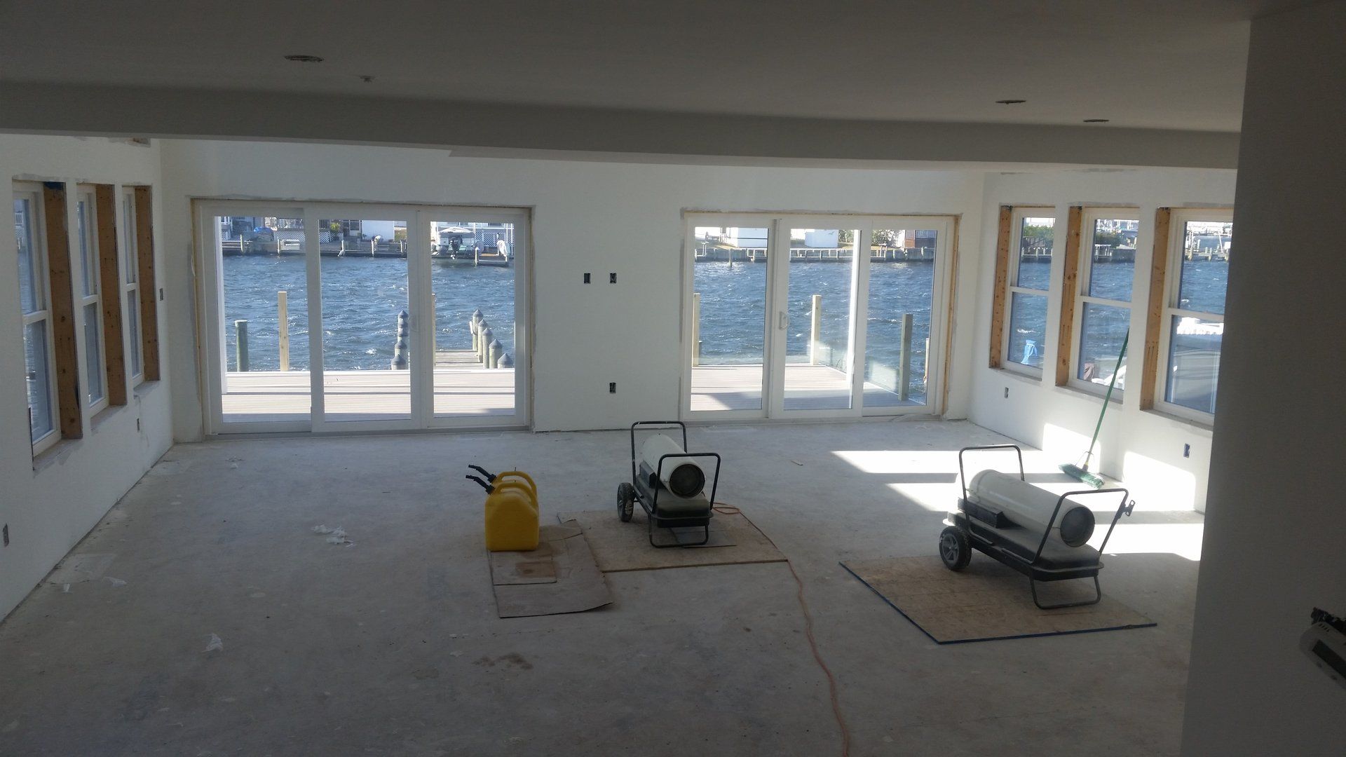 An empty room with a lot of windows and a view of the water