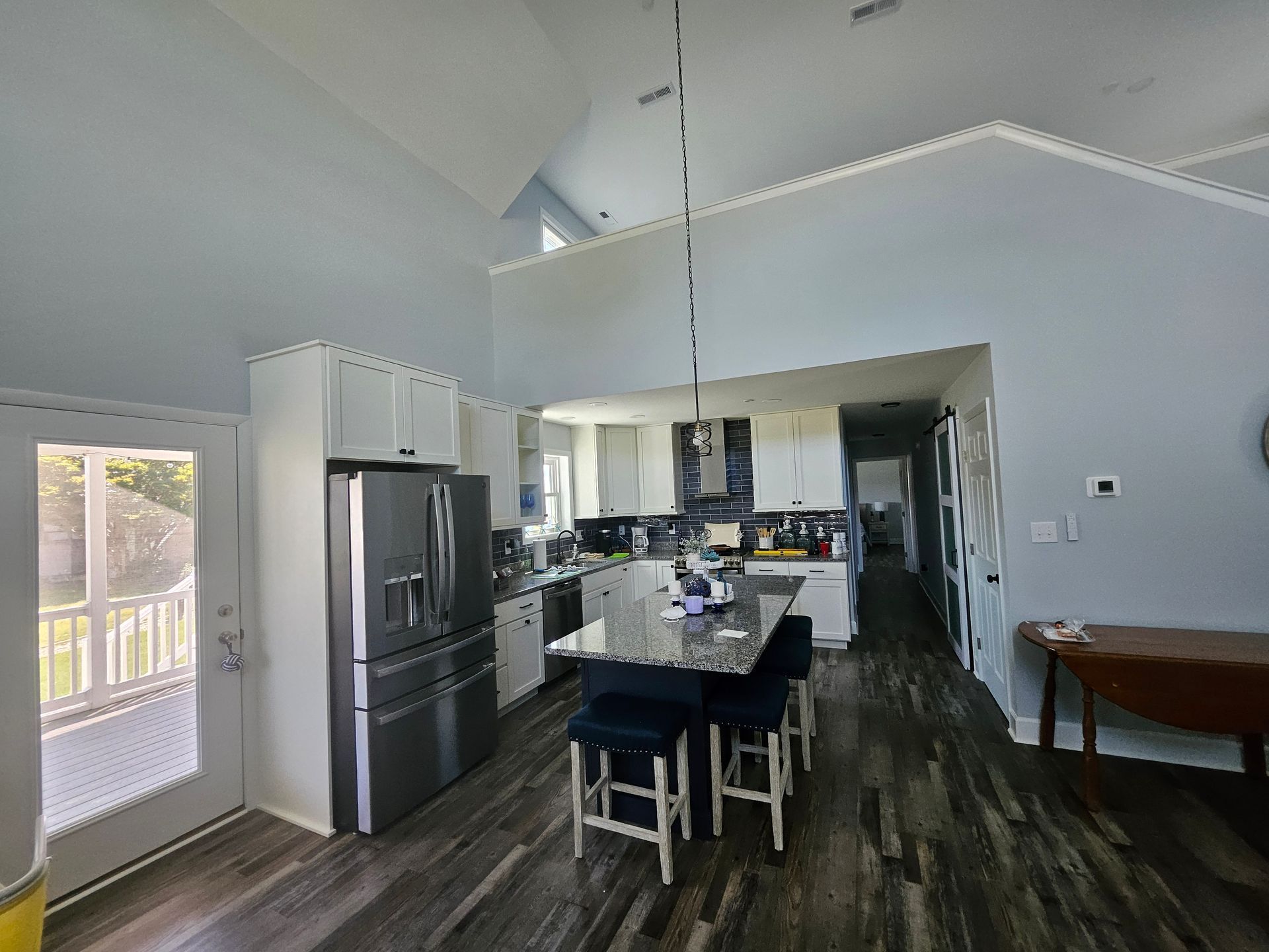 A kitchen with stainless steel appliances and a large island with a table and chairs