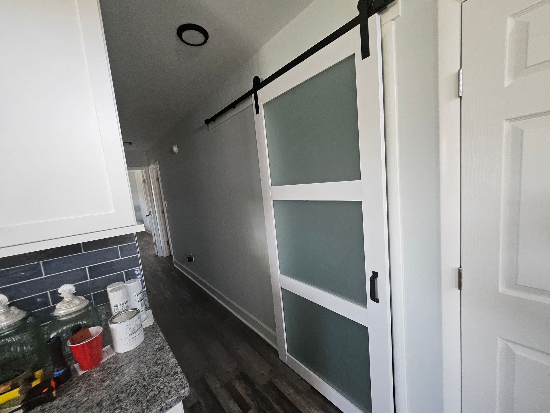 A hallway with a sliding barn door in a kitchen