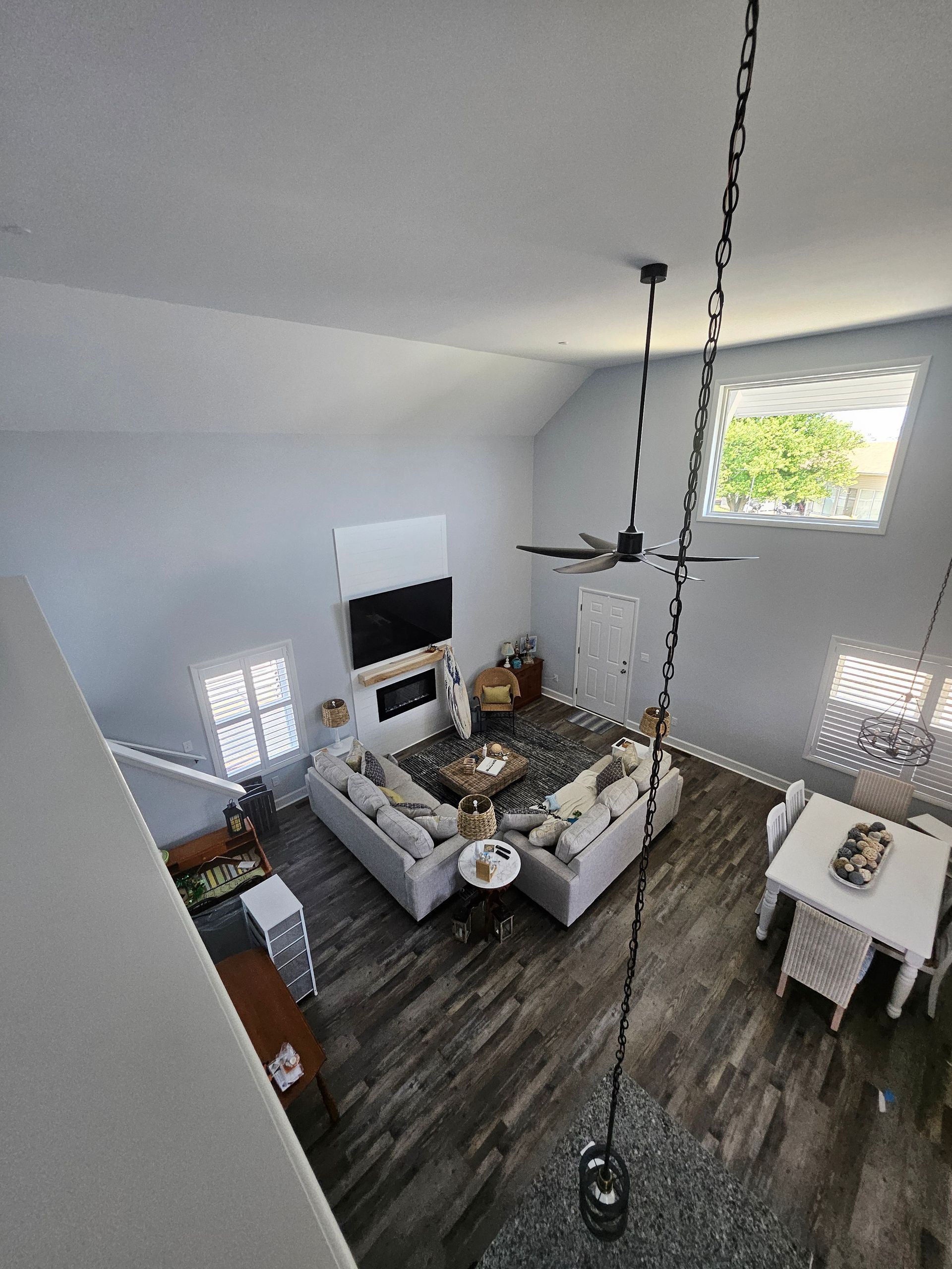 An aerial view of a living room and dining room from the second floor