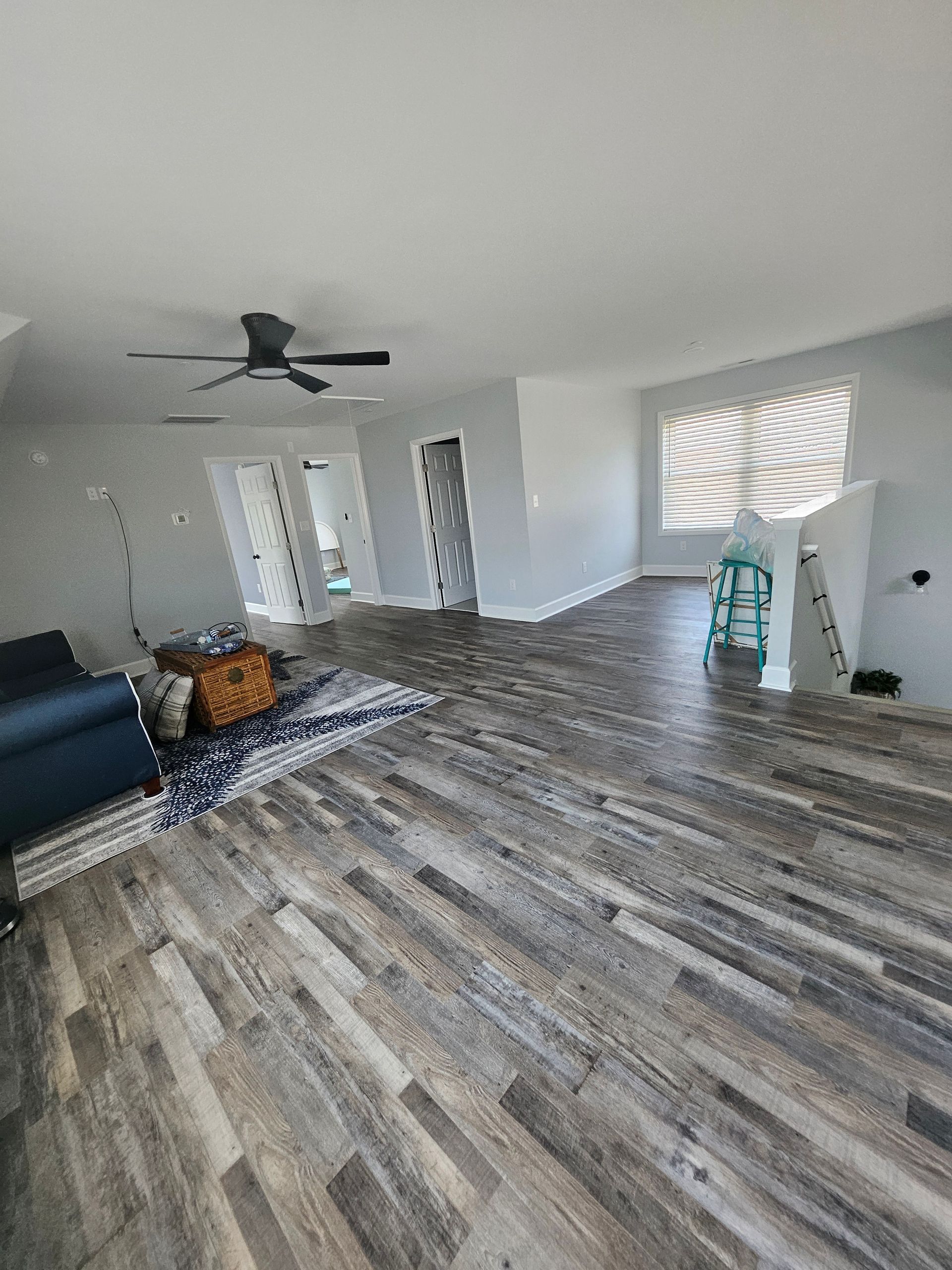 A living room with hardwood floors and a ceiling fan