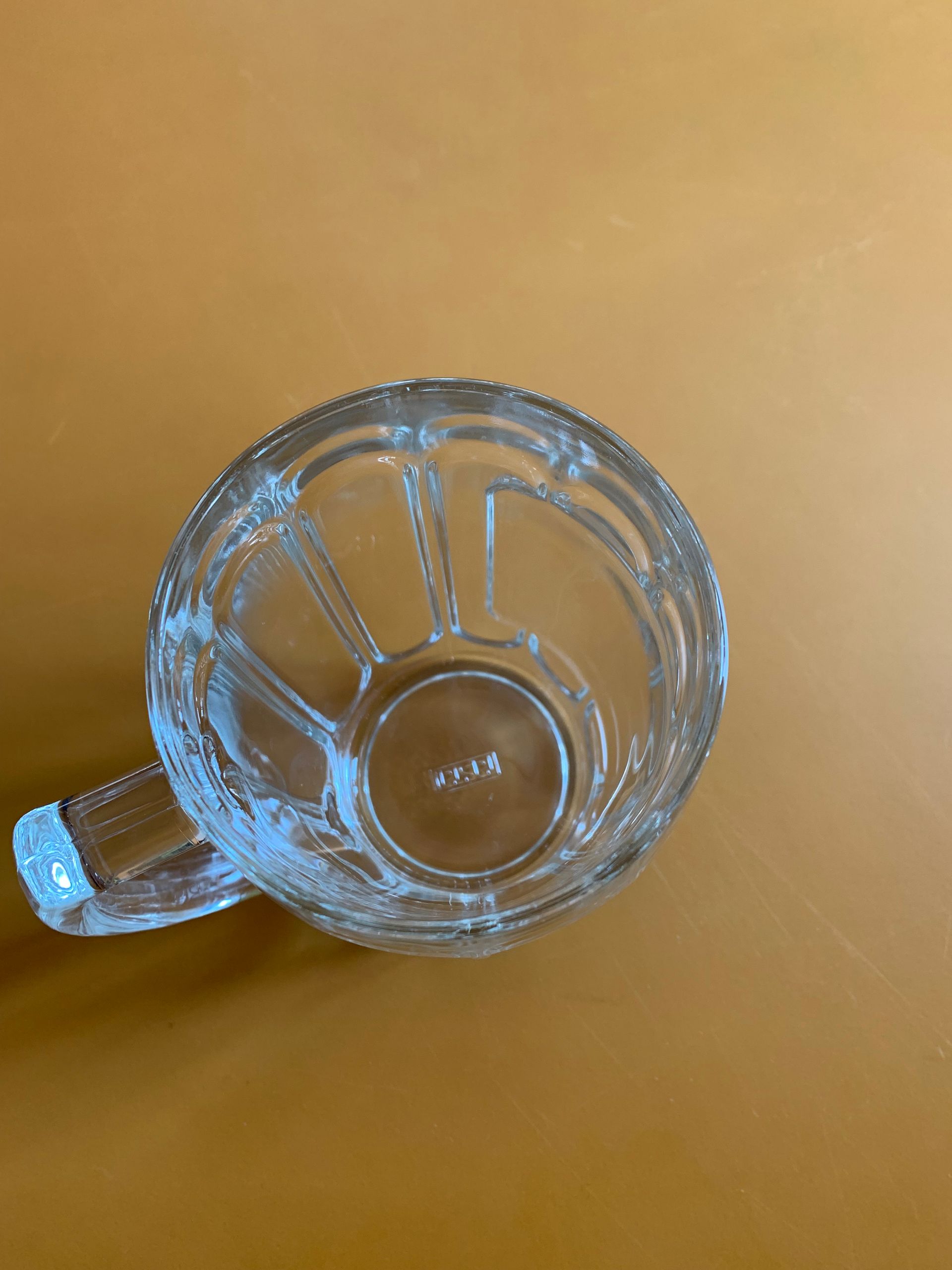 A clear glass mug with a handle