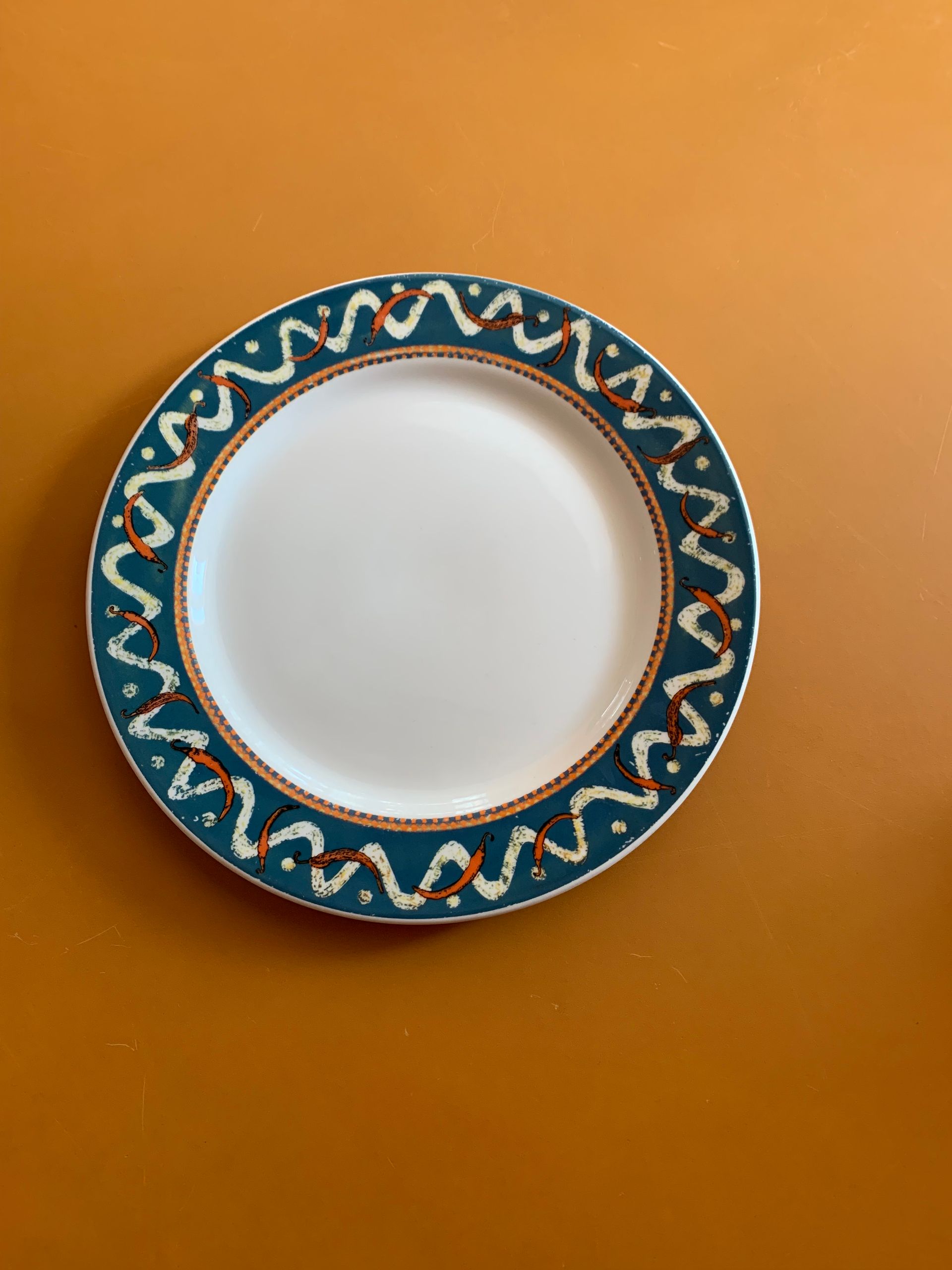 A white plate with a blue rim and a pattern on it