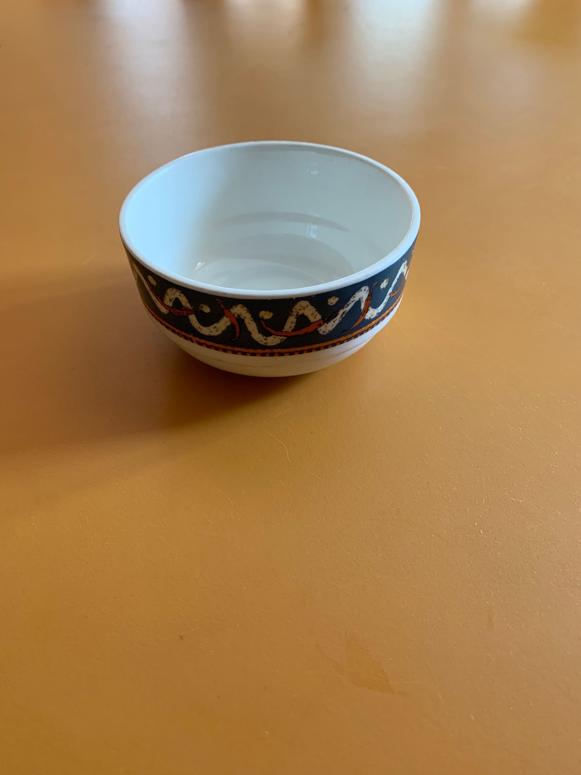 A small bowl is sitting on a wooden table