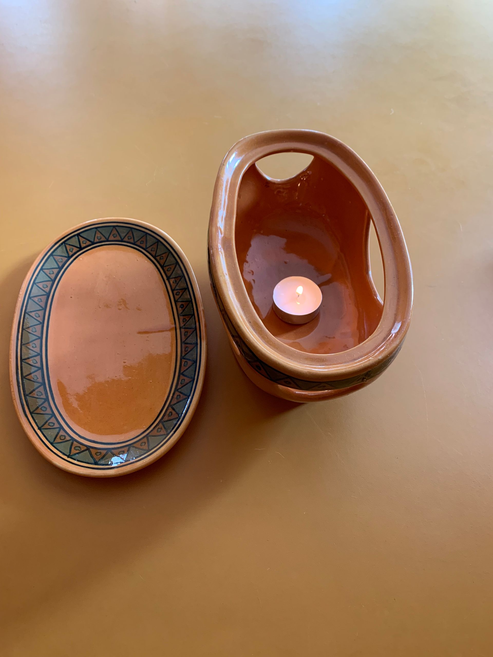 Two plates and a bowl with a candle in it on a table