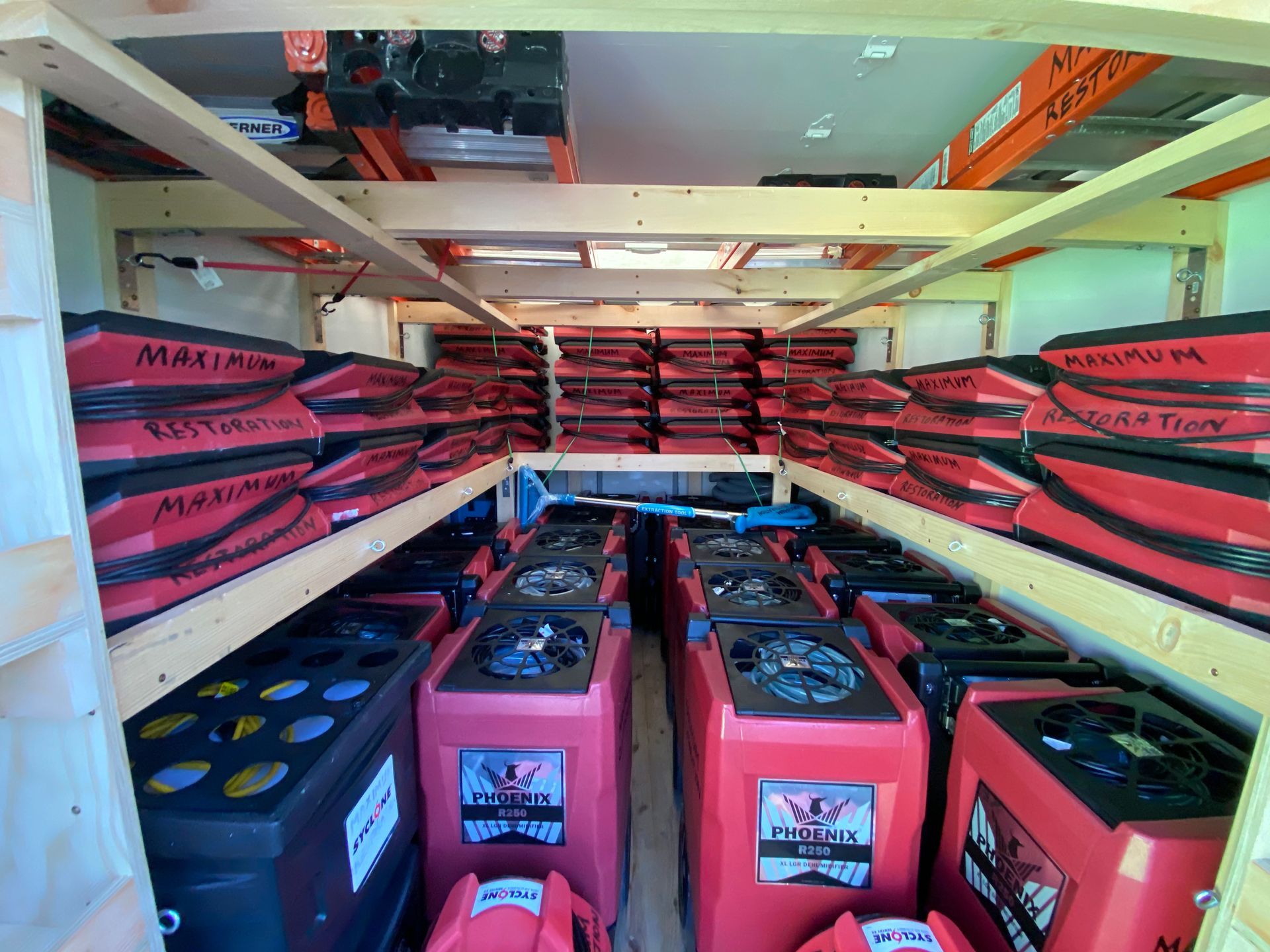 A cargo area filled with numerous red and black dehumidifiers and stored equipment.