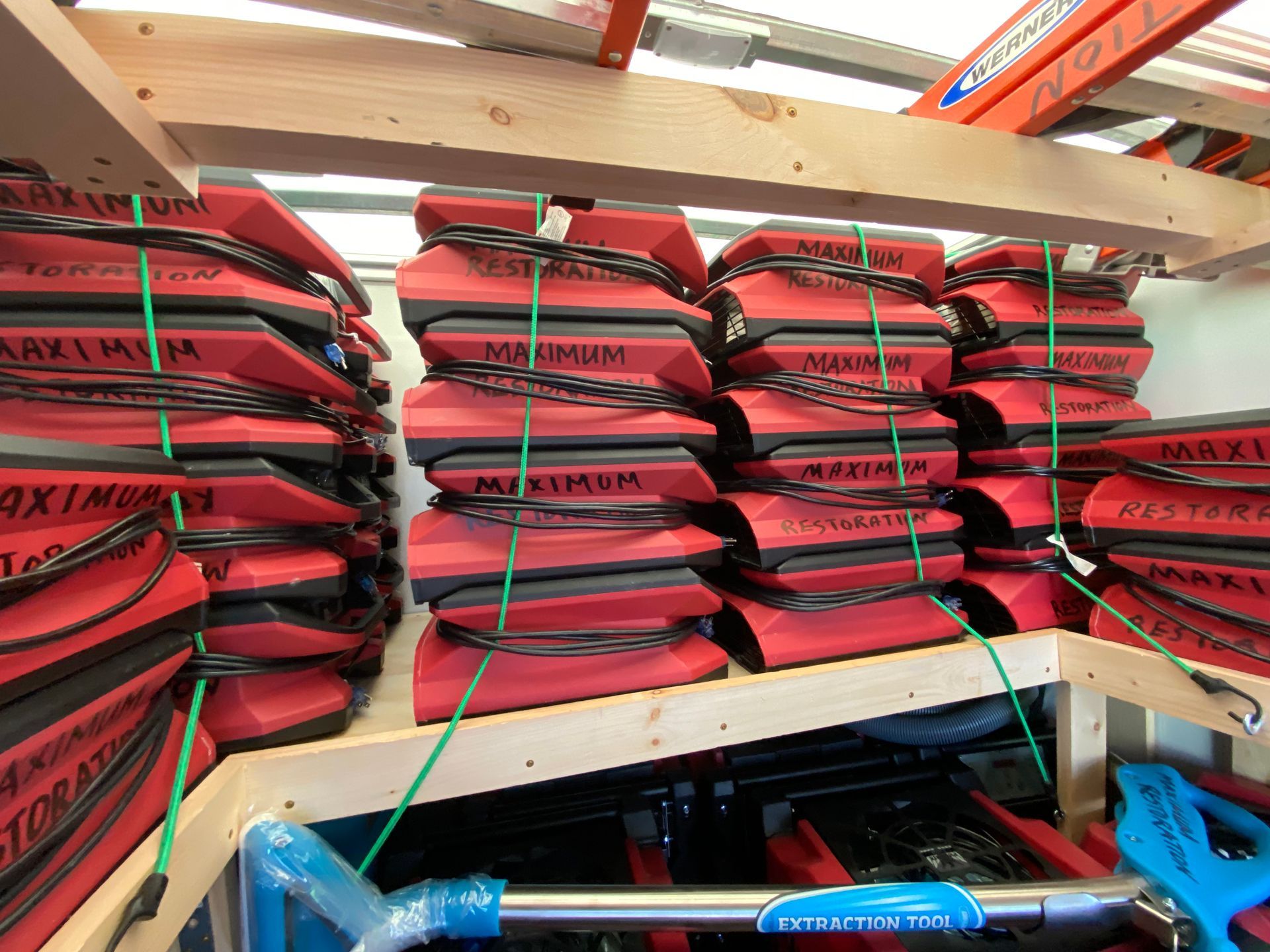 Red and black pads stacked on wooden shelves, secured with green string.