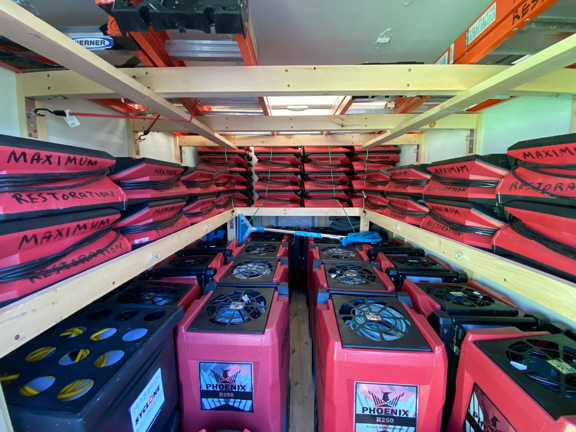 Inside a truck: Rows of red and black restoration equipment.