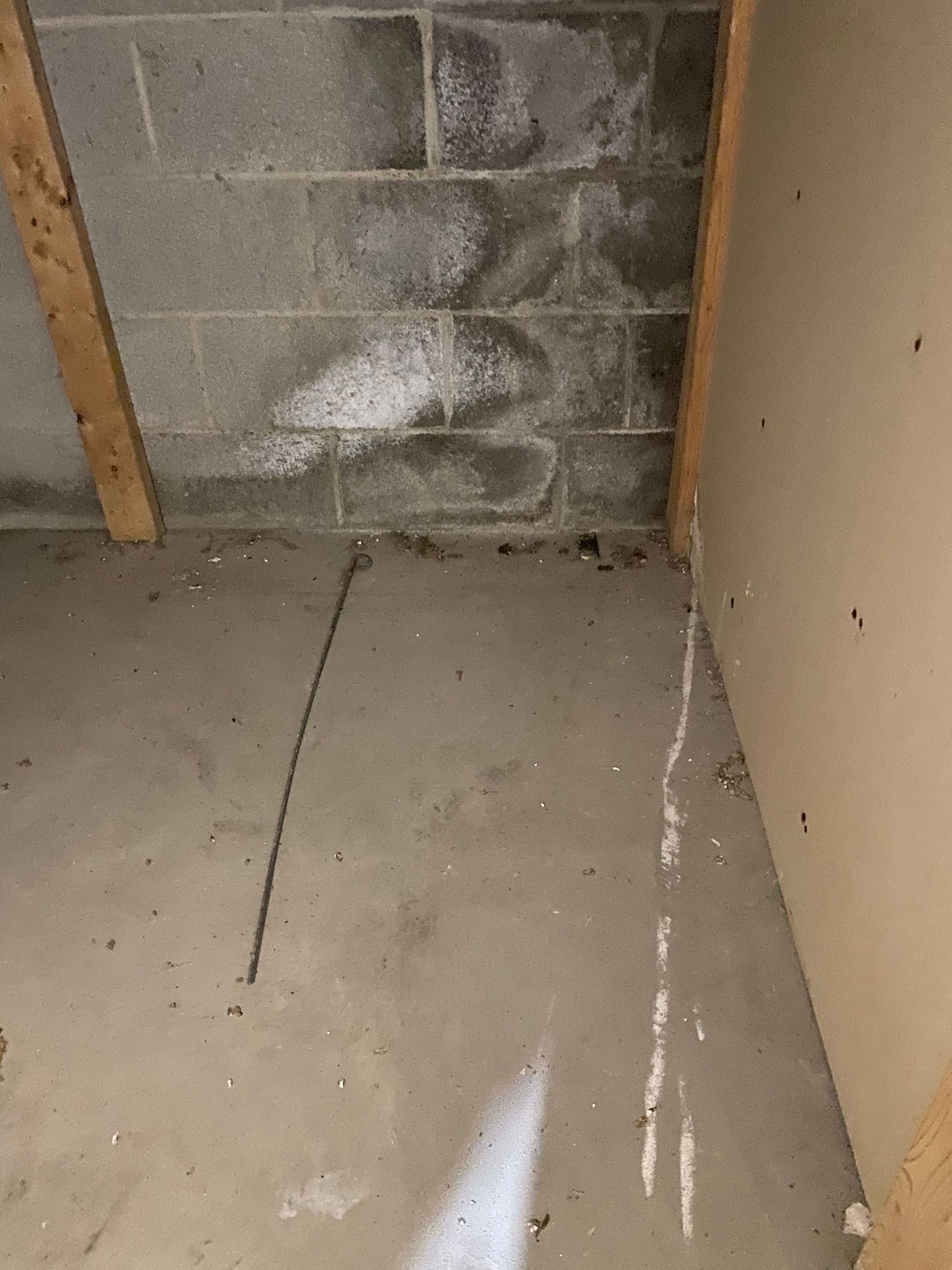 Concrete block wall with white efflorescence, corner of a room.