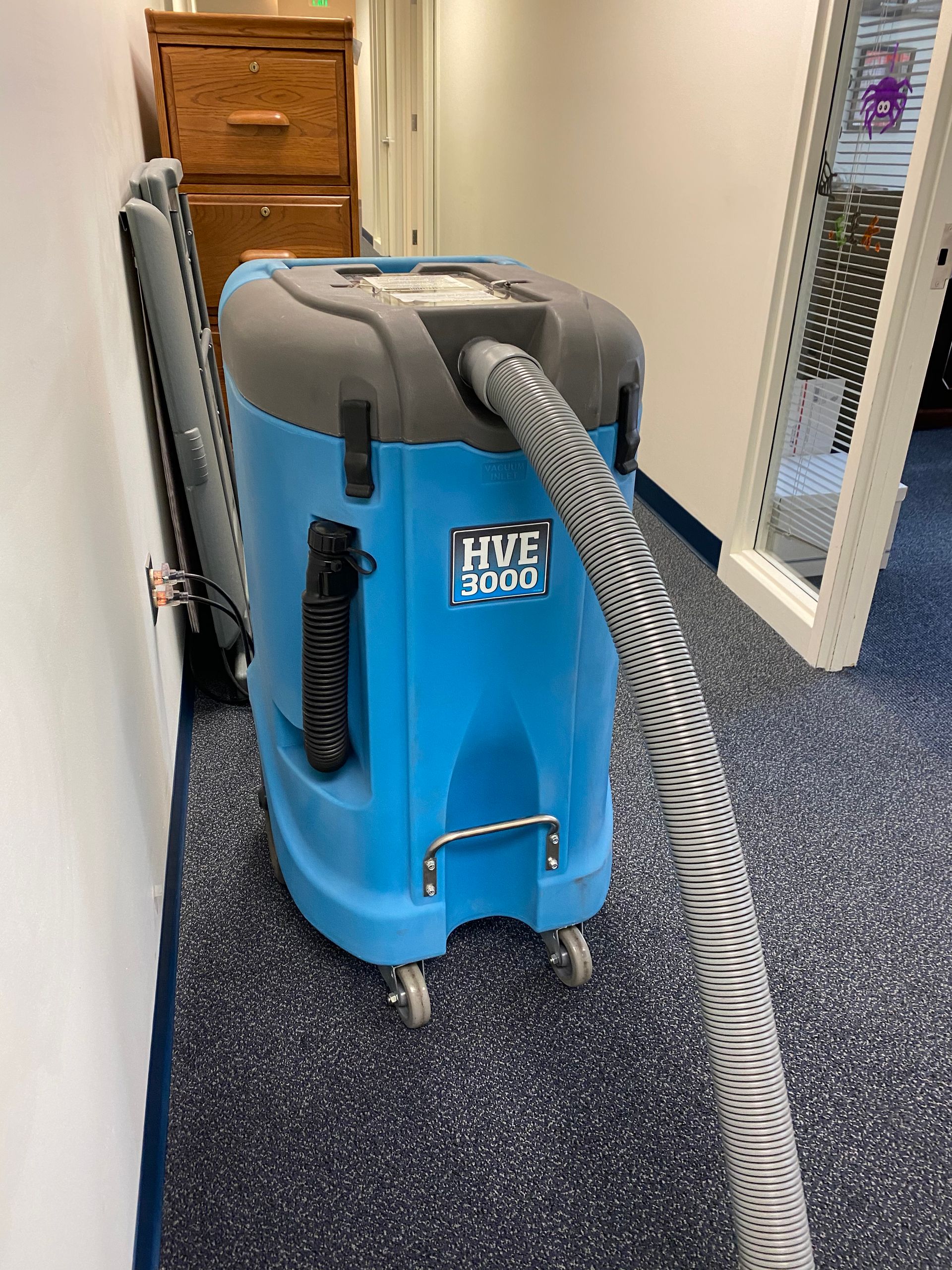 Blue and black industrial vacuum cleaner, labeled 