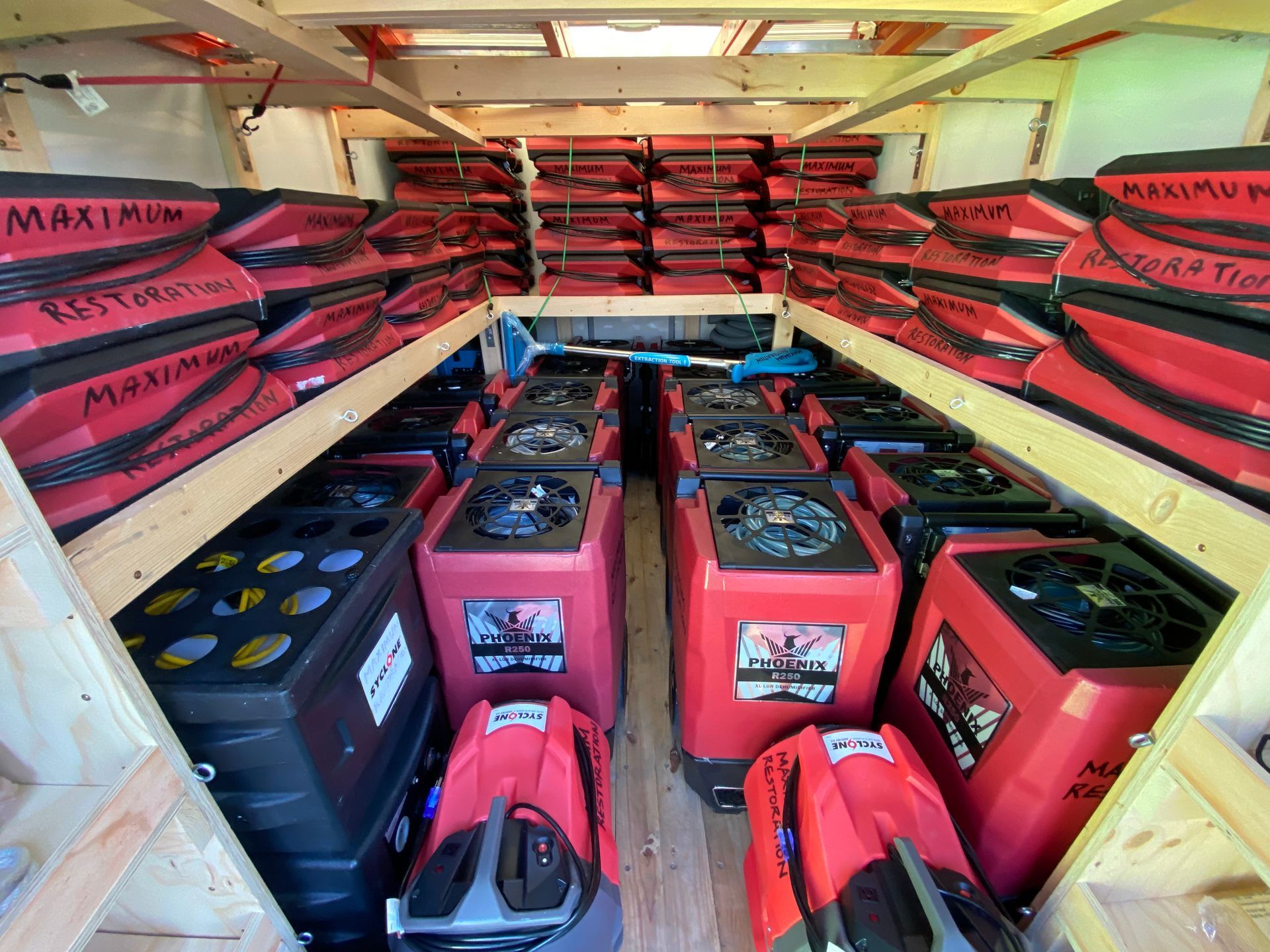 Interior of a truck filled with red and black restoration equipment, likely for water damage.