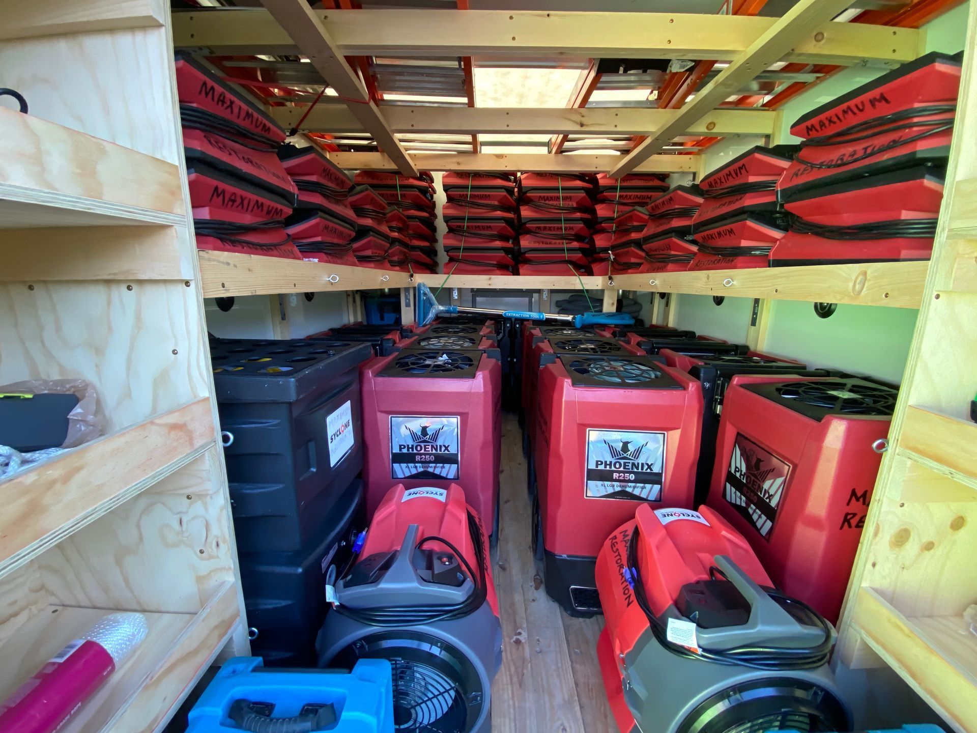 Interior of a van filled with rows of red and black industrial machines and equipment.