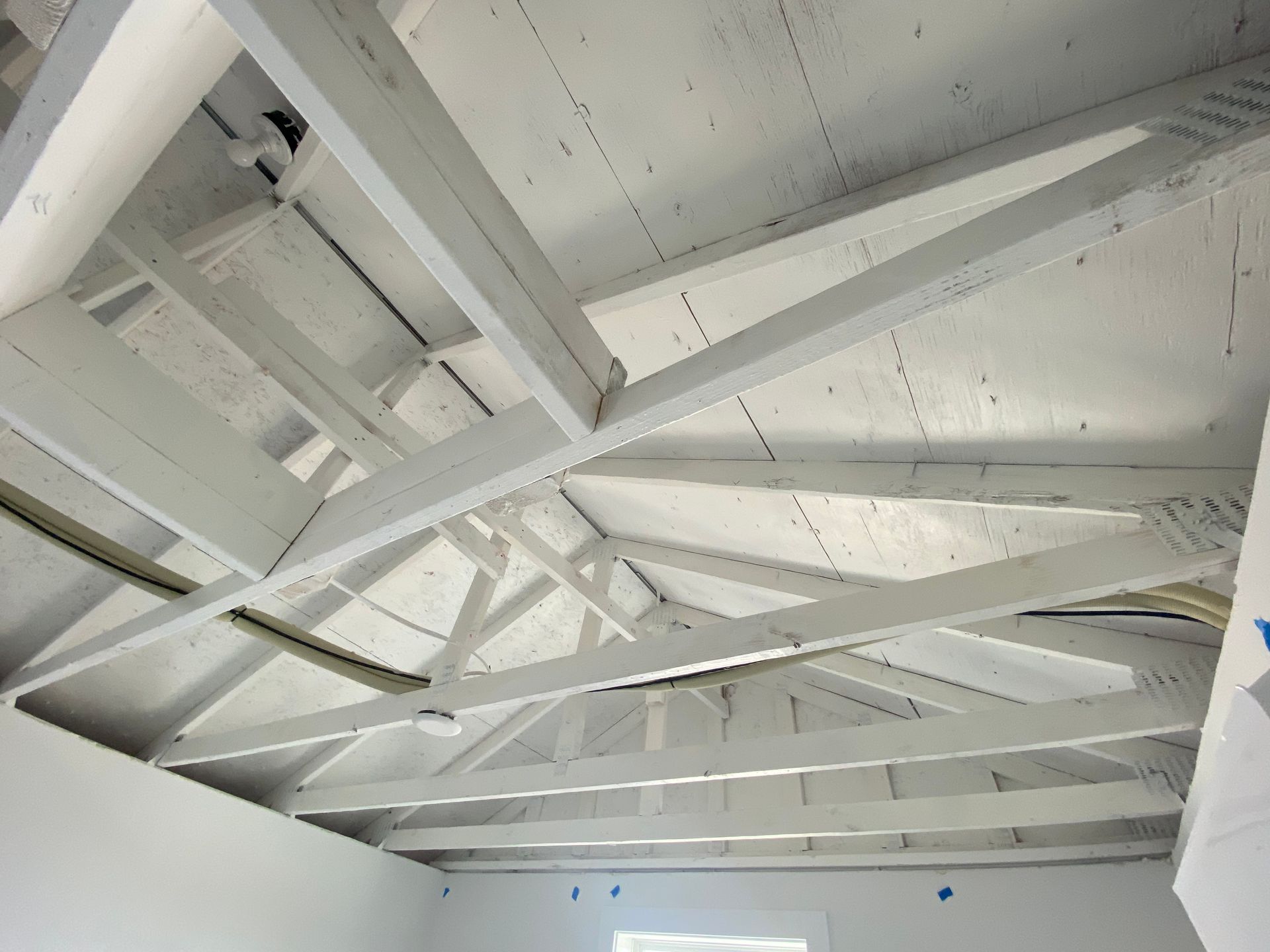 White-painted interior ceiling with exposed beams and trusses.