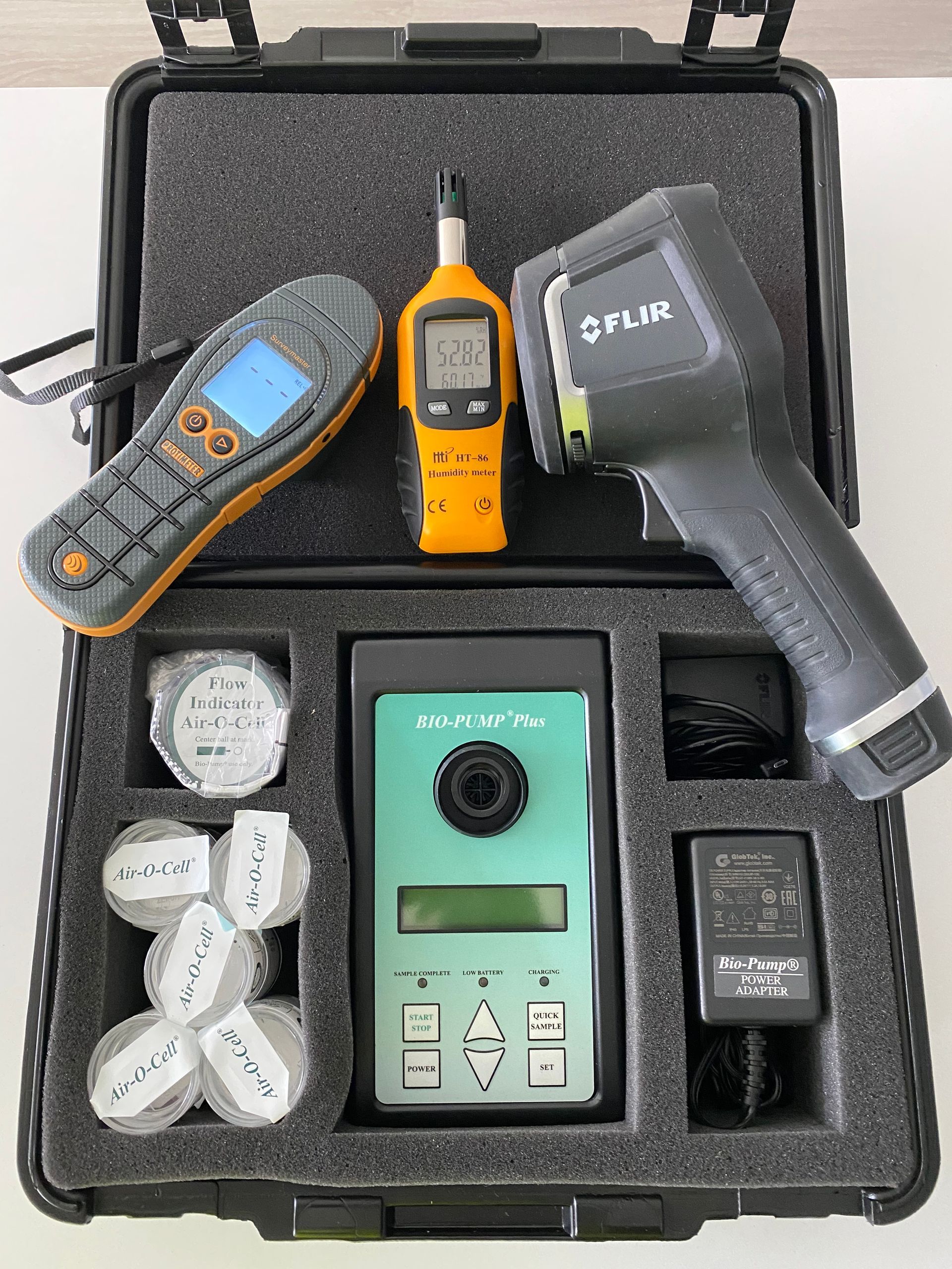 A hard-shell carrying case filled with various professional diagnostic tools, including a thermal camera and sensors.