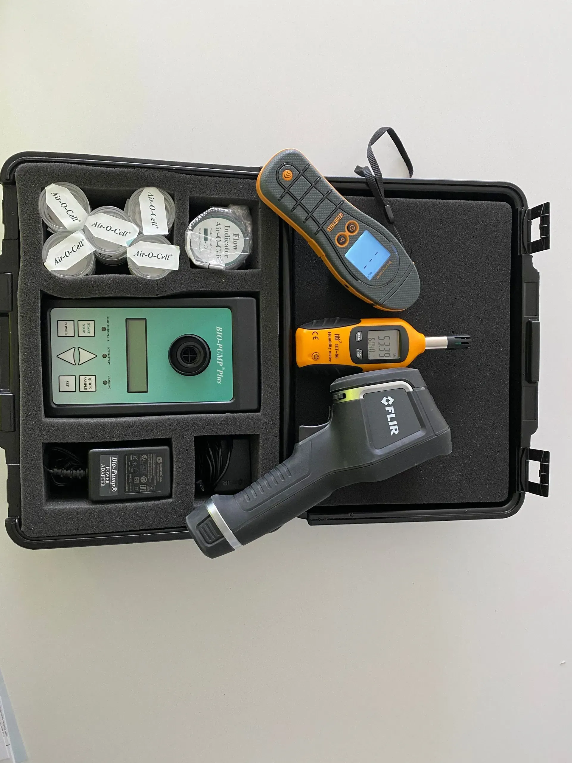 A case containing various industrial measuring tools, including an infrared thermal camera, digital meters, and sensors.