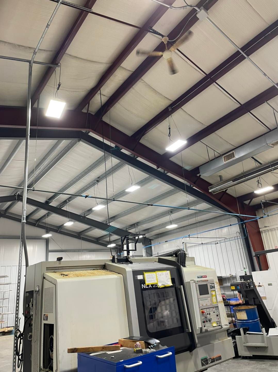 Interior of an industrial warehouse with large machinery and high metal ceiling lights