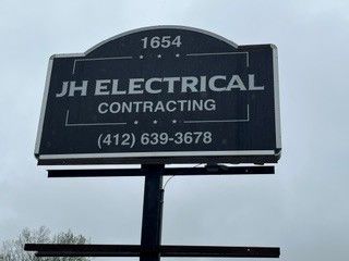 JH Electrical Contracting sign with phone number 412-639-3678 on a dark roadside board