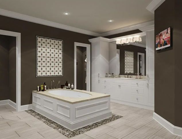 A luxurious brown-walled bathroom with a white-trimmed tub, vanity, and light-colored tile floor. The room is well lit.