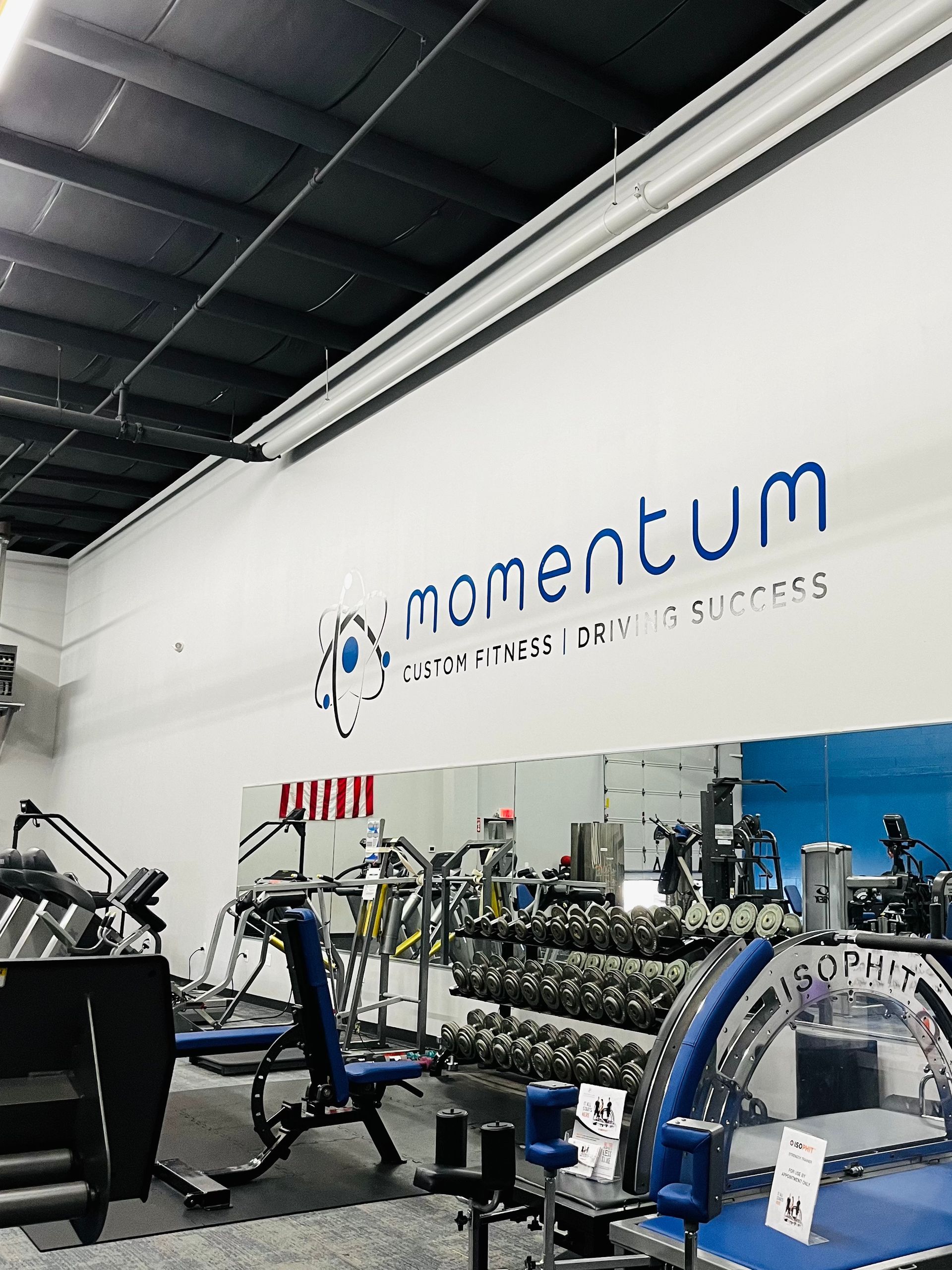 A gym with a wall that says momentum on it.