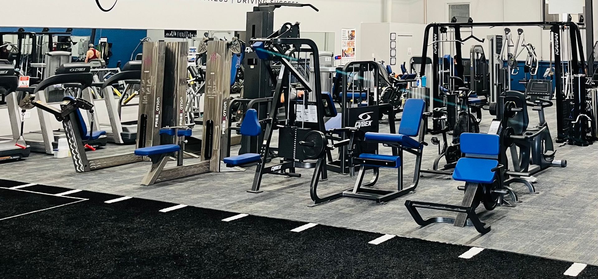 A gym filled with lots of different types of exercise equipment.