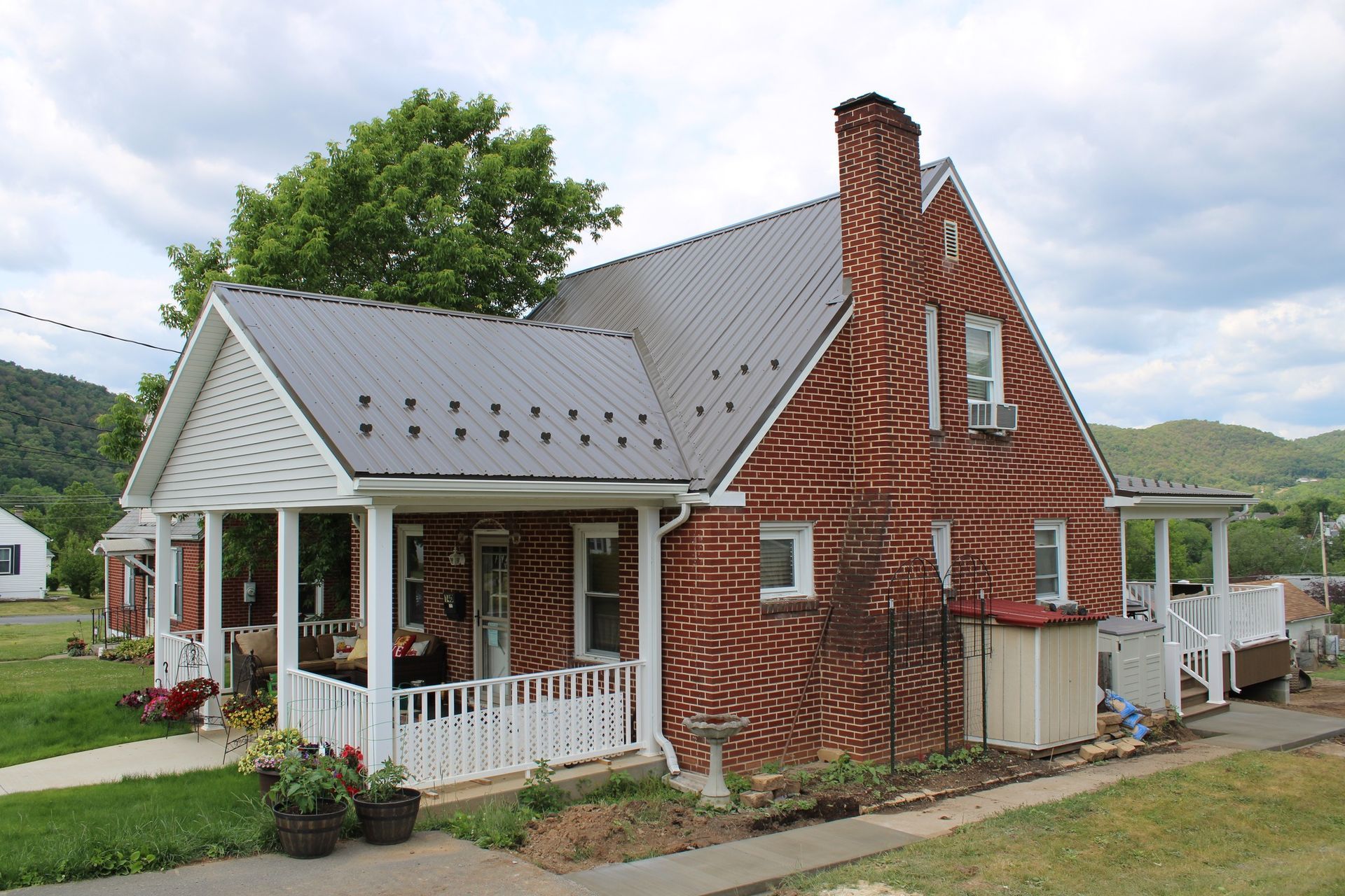 A brick house with a porch and a chimney
