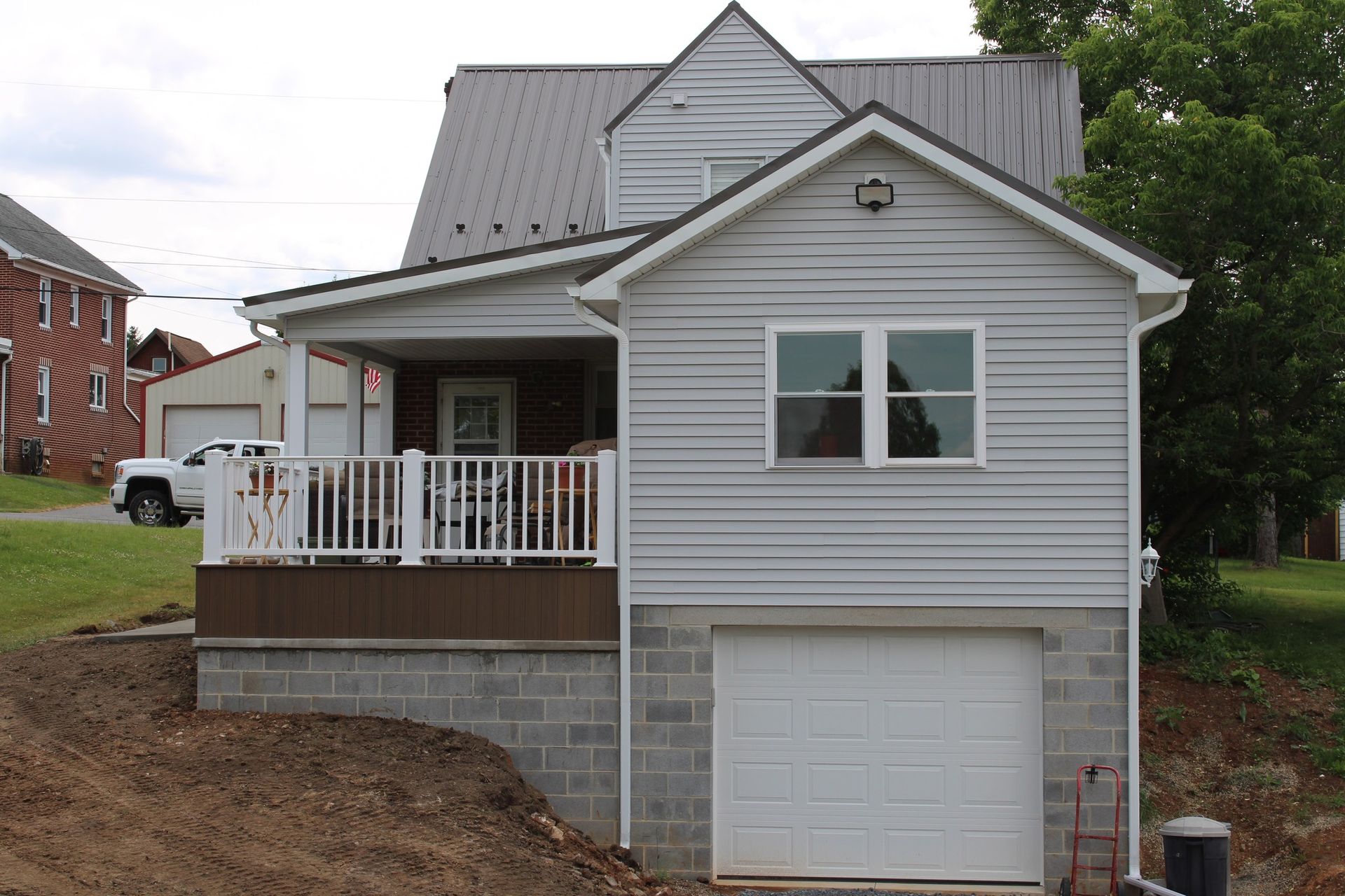 A small white house with a garage and a porch.