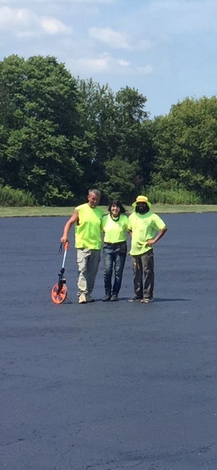 3 team members on a newly paved surface
