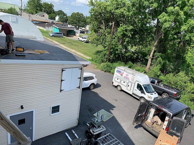 A man is working on the roof of a building.