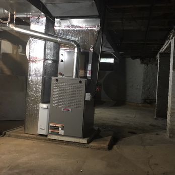 An air conditioner is sitting in the middle of an empty room.