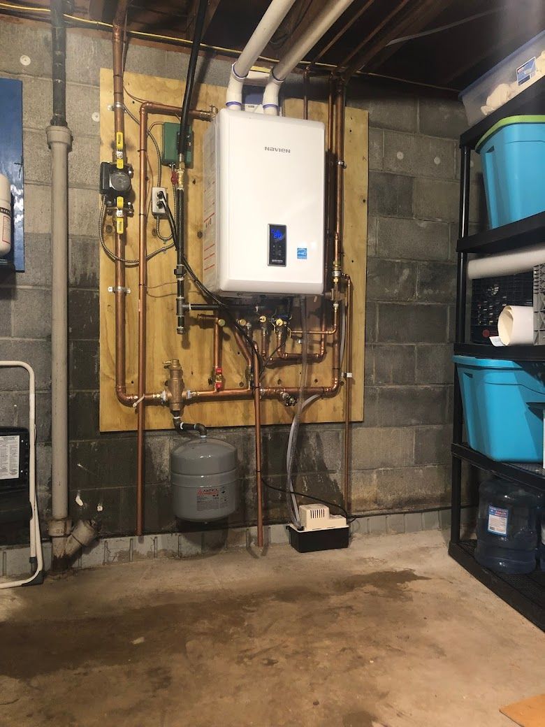 A basement with a boiler and a lot of pipes.