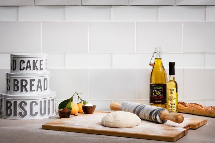 A wooden cutting board with dough and a rolling pin on it.