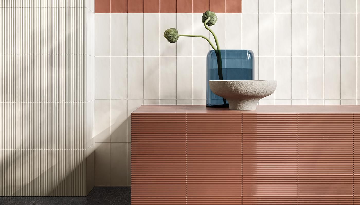 A vase of flowers is sitting on a counter in a bathroom.