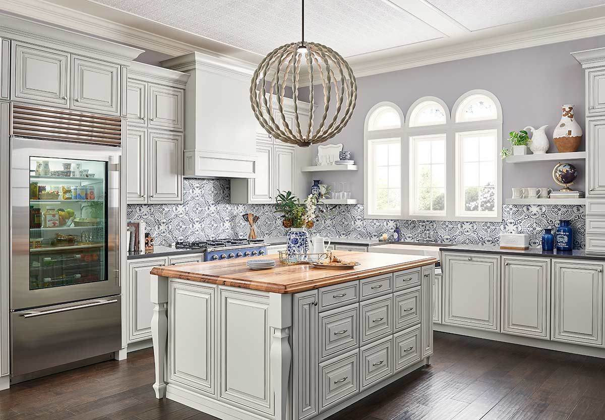 A kitchen with white cabinets and a large island in the middle.