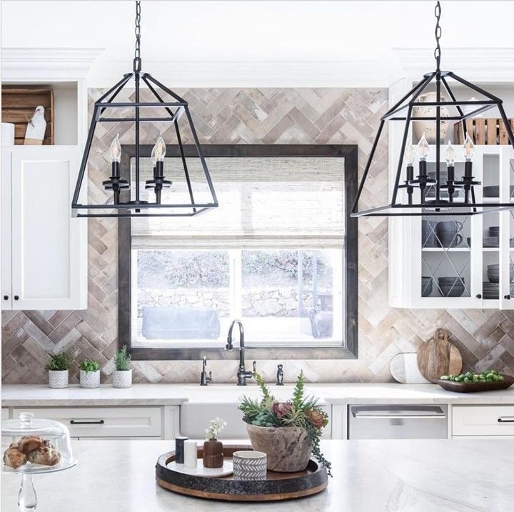 A kitchen with white cabinets , a sink , and a window.