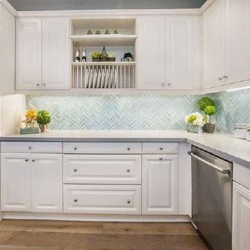 A kitchen with white cabinets and a stainless steel dishwasher.