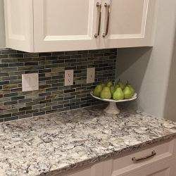 A kitchen counter with a bowl of pears on it.