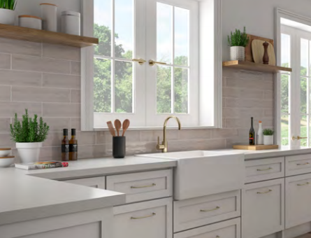 A kitchen with white cabinets , a sink , and a window.