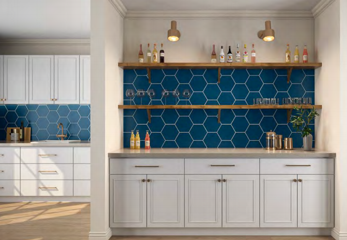 A kitchen with white cabinets and blue hexagon tiles on the wall.