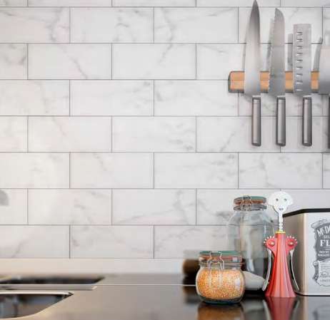A kitchen counter with knives hanging on the wall